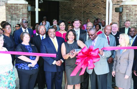 Group of officials cut red ribbon for ribbon cutting for inter-governmental complex