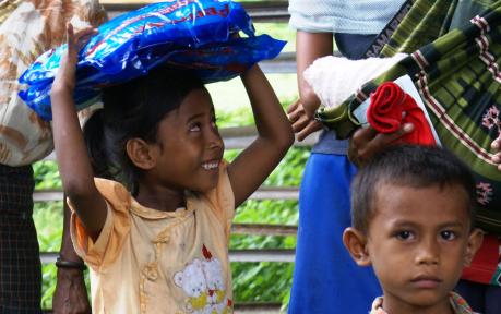 A young girl in Timor-Leste carries home an insecticide treated net from a distribution site for the USAID Timor-Leste Health Im