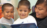 a woman reading to two boys