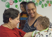 A teacher, a mother, and a child laughing