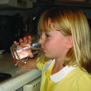 Photo of a young girl drinking water, which likely originated from groundwater sources. 