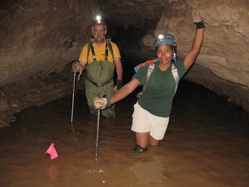 A man and woman explore walk through water in a cave in New Mexico. BLM photo.