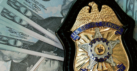 A Secret Service badge laying on various U.S. currency