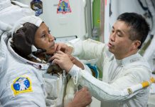 Koichi Wakata (right) helping Jeanette Epps fasten something on space suit (NASA)