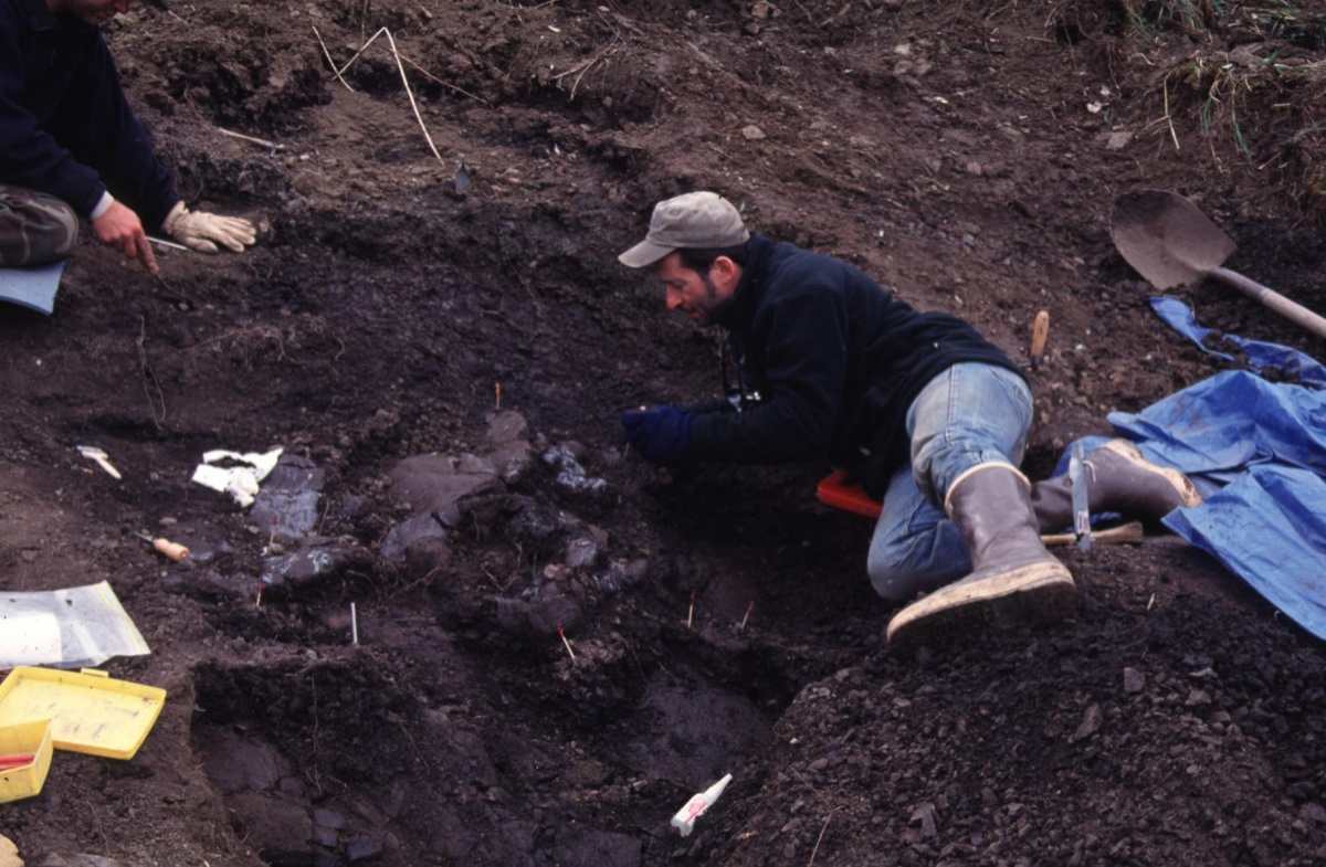 Dr. Anthony R. Fiorillo laying down in the dirt using hand tools unearthing Pachyrhinosaurus perotorum fossils, along the Colville River. Photo by courtesy of Dr. Anthony R. Fiorillo and the Museum of Nature and Science in Dallas.