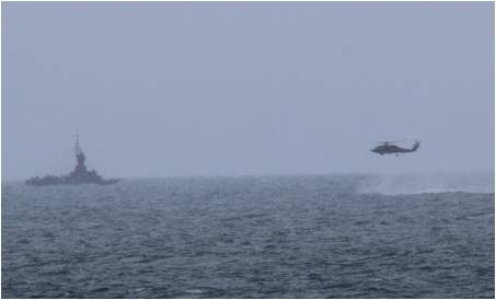 JAVA SEA (Dec. 31, 2014) An MH-60R Sea Hawk helicopter attached to the guided-missile destroyer USS Sampson (DDG 102) approaches an Indonesian navy patrol vessel while searching for debris during the Indonesian-led search and recovery operations for AirAsia flight QZ8501. Sampson is homeported in San Diego and is on an independent deployment to the western Pacific region. Photo courtesy of U.S. Navy.