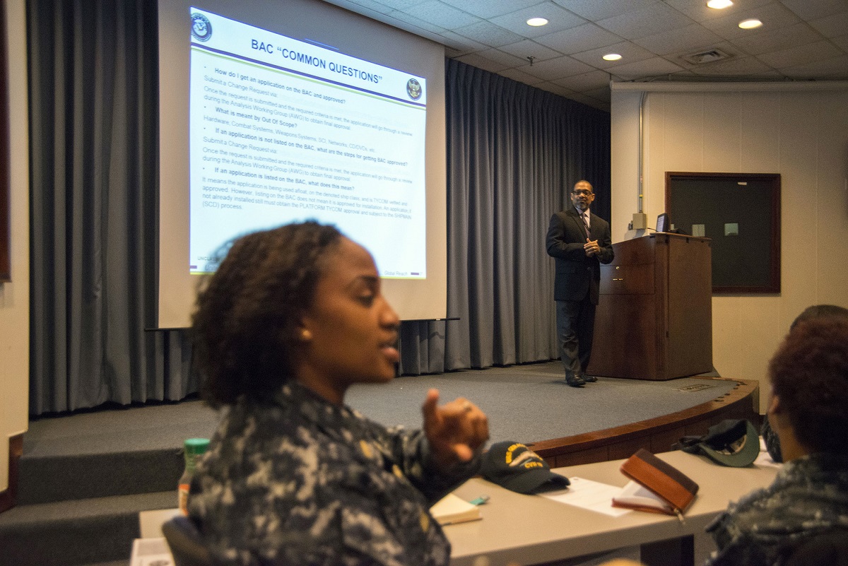 NORFOLK (April 18, 2016) -- Ken Brown, (center right) Fleet FAM/FAST team member and instructor listens intently to Ensign Tara Mark, (left) Information System Security Manager for Pre-Commissioning Unit Gerald R. Ford (CVN 78) as she enquires about baseline allowance control (BAC) lists during the Fleet Waterfront Applications Workshop held April 18-20 on Norfolk Naval Station.  The Fleet Waterfront Applications Workshop hosted by Naval Information Forces (NAVIFOR) Fleet Functional Area Manager (FAM), provides training and best practices to the Fleet regarding shipboard network systems and applications.  U.S. Navy photo by Michael J. Morris