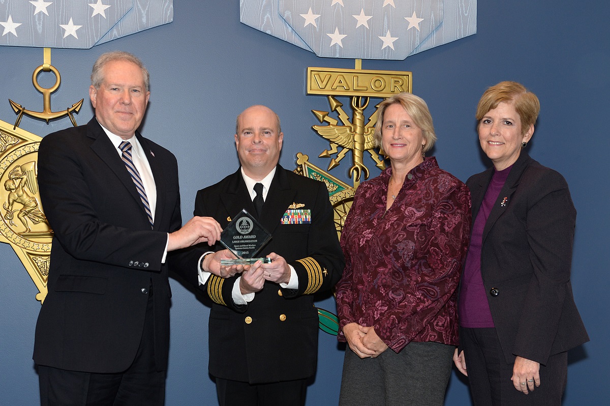 The Honorable Frank Kendall, under secretary of Defense for Acquisition, Technology and Logistics, recognized Space and Naval Warfare Systems Center Pacific (SSC Pacific) Commanding Officer Capt. Kurt Rothenhaus with the 2015 Defense Acquisition Gold Workforce Development Award for a Large Organization, Dec. 10, 2015, at the Pentagon Hall of Heroes in Arlington, Virginia. Pictured (left to right): Sec. Frank Kendall, Capt. Kurt Rothenhaus, Lynn Collins, ISR/IO department head, and Angela Hanson, Civilian Workforce director.