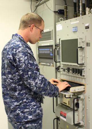 Information Systems Technician 3rd Class Cameron Evans performs the initial start-up of Naval Computer and Telecommunications Area Master Station, Pacific’s newly installed AN/FSC-138 Navy Multiband Terminal May 8, 2015.