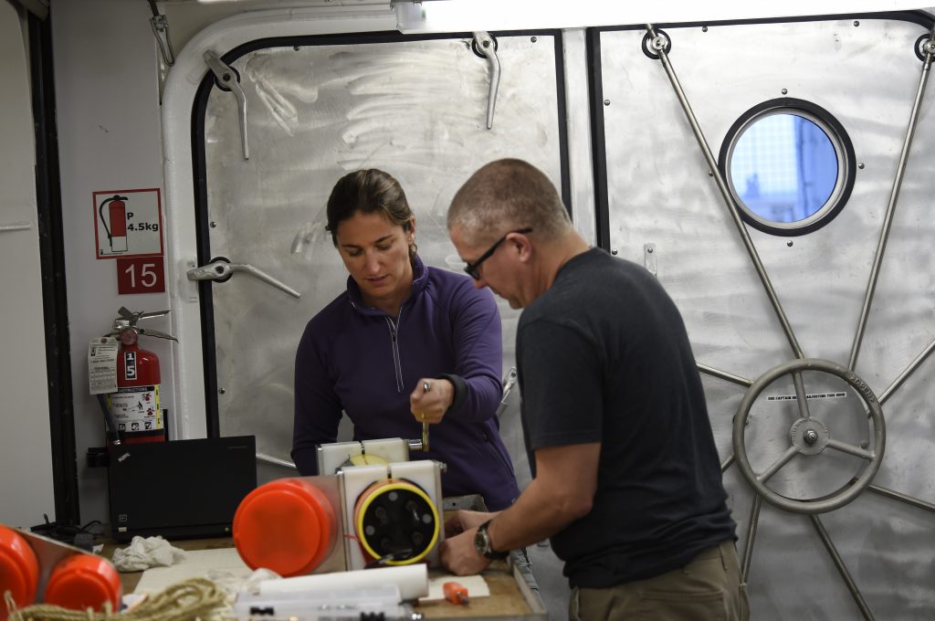 Ana Sirovic, a research scientist with Scripps Institution of Oceanography, and Joe Warren from Stony Brook University, work on a echo sounder in the wet lab aboard the Auxiliary General Oceanographic Research (AGOR) vessel R/V Sally Ride. Sally Ride is currently conducting a series of science verification cruises in order to test its installed systems and ensure its readiness for conducting future research missions. U.S. Navy photo by John F. Williams/Released 