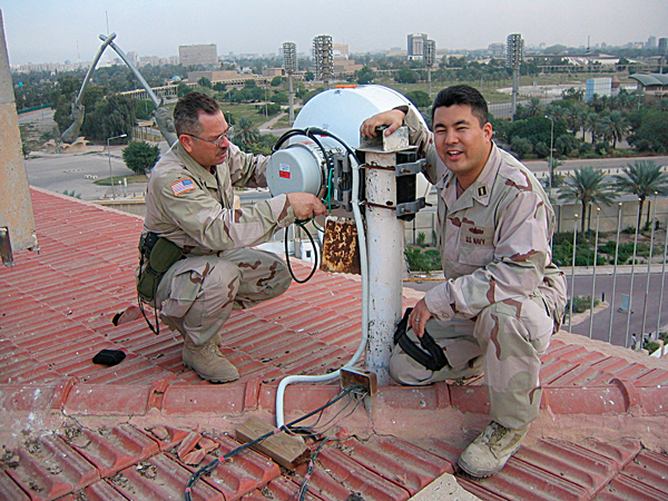 IT2 Velez Charles and Lt. Dale Shigekane on the roof of Adnon Palace installing a microwave antenna to provide voice and data services to the National Joint Operations Center. Shigekane and Charles work in the U.S. Embassy in the IZ. Shigekane is the director of network operations for the the U.S. Embassy for the MNF-I Coalition Information Coalition Sharing (CIS) Forward.