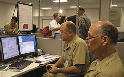 Cmdr. Mark Hottendorf (right, foreground) and OSCS Kevin Albright using InfoWorkSpace, a real-time virtual environment for information sharing.
