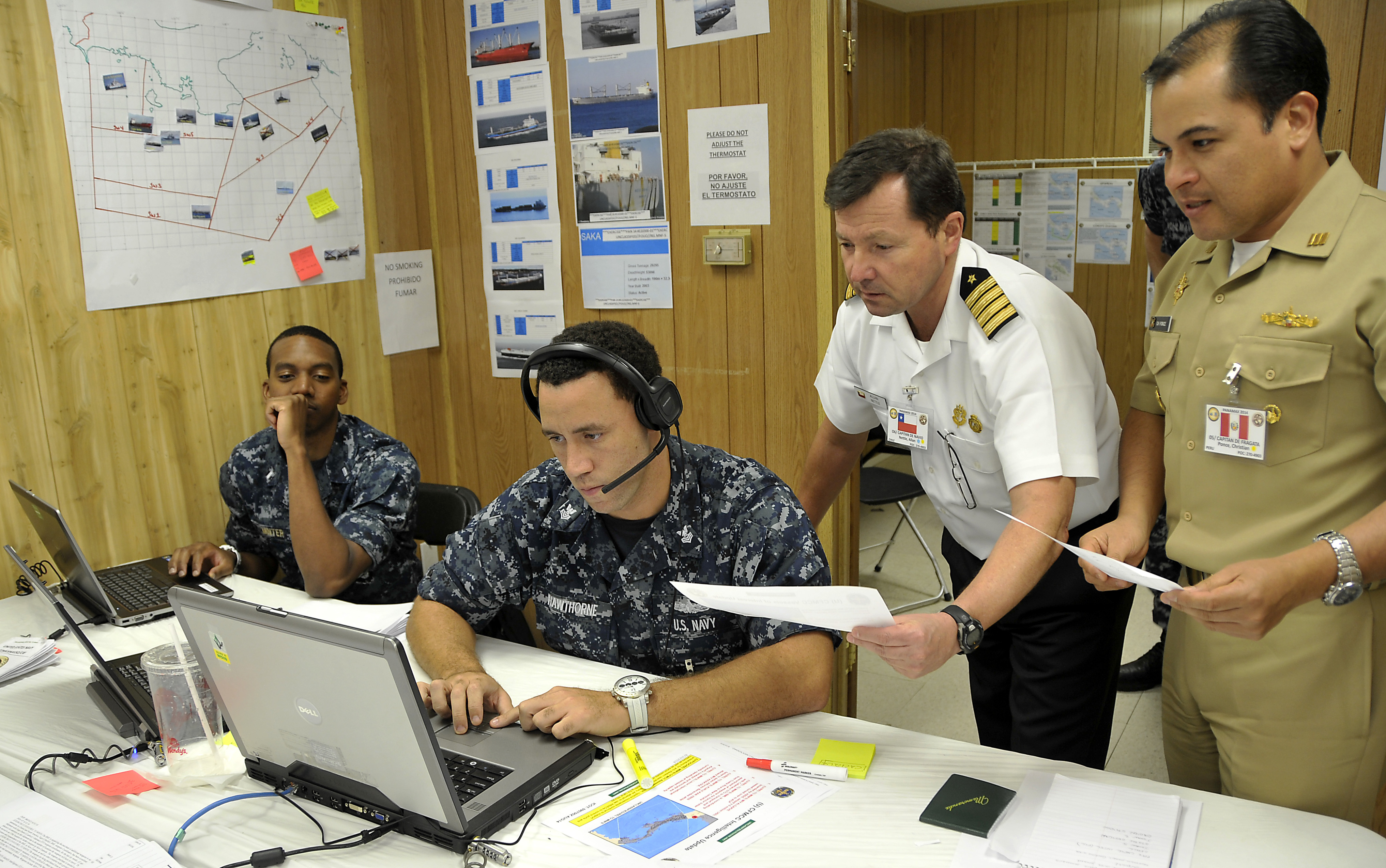 MAYPORT, Fla. (Aug. 10, 2014) Operations officer Lt. j.g Daniel Minter, left, Operations Specialist 1st Class Gavin Hawthorne, Chilean navy Capt. Allan Nettle, Commander of Command Task Force, and Peruvian Capt. Christian Ponce, all members of Command Task Force 801, discuss high value target locations during PANAMAX 2014 at Naval Station Mayport. PANAMAX is an annual U.S. Southern Command-sponsored Exercise series that focuses on ensuring the defense of the Panama Canal. U.S. Navy photo by Mass Communication Specialist 1st Class Andre N. McIntyre.