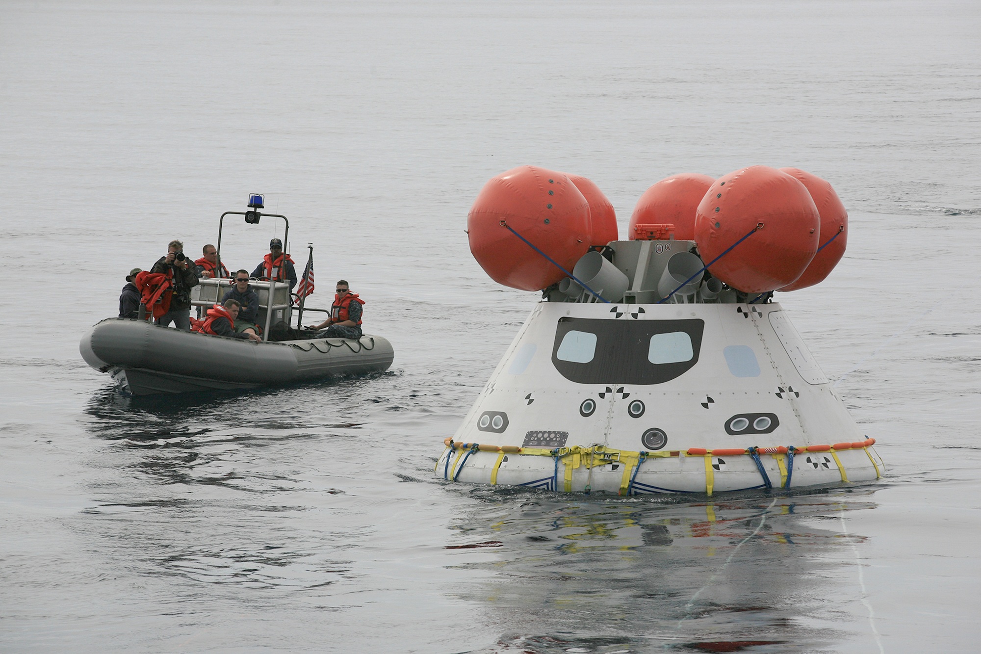 U.S. Navy personnel use a rigid hull inflatable boat to approach the Orion boilerplate test article during an evolution of the Underway Recovery Test 2 in the Pacific Ocean off the coast of San Diego, California on Aug. 2, 2014. NASA photo by Kim Shiflett.