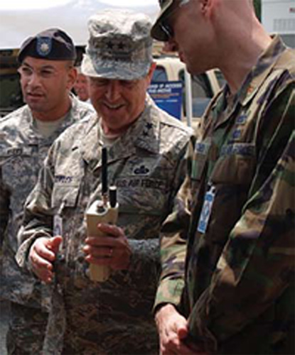 On a tour of CWID, National Guard Bureau Director of C4, Maj. Gen. Alan Cowles, holds a prototype phone designed for satellite-based communications. The phone system or "infrastructure in the sky," a Marines Corps Warfighting Lab project, can help commanders track their troops on the ground. It brings connection times from 30 to 45 seconds down to just two. Photo courtesy of NSWC Dahlgren Division.