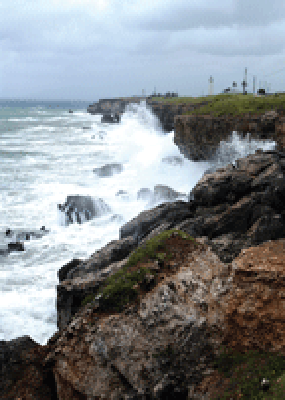 Waves crash against the southern coastline of Naval Station Guantanamo Bay, Cuba, just east of the base lighthouse July 8, 2005. U.S. Navy photo by Photographer’s Mate 1st Class Terry Matlock.