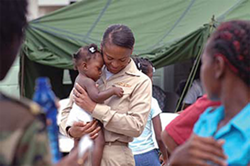 Republic of Suriname (Oct. 5, 2007) - Lt. Cmdr. Andrea Petrovanie, attached to Military Sealift Command hospital ship USNS Comfort (T-AH 20), calms a pediatric patient at Flustraat Clinic in Paramaribo, Suriname. U.S. Navy photo by Mass Communication Specialist 2nd Class Steven King.