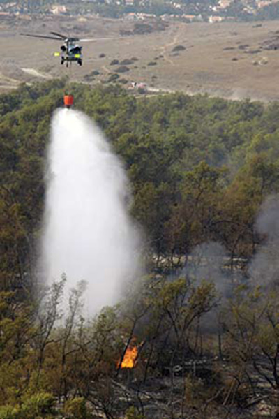 An MH-60S Seahawk helicopter assigned to HSC 85 dumps 420 gallons of water on wildfires burning in San Diego County. HSC-85 teamed up with the San Diego Department of Forestry and Fire Protection to help put out the wildfires blazing across Southern California. U.S. Navy photos by MC Seaman Jon Husman.