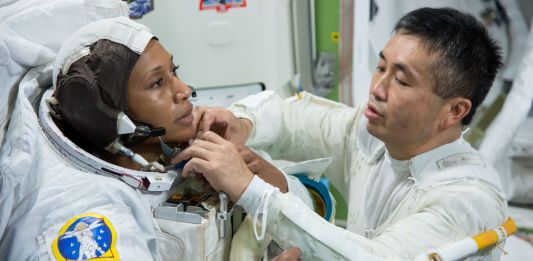 L’astronaute japonais Koichi Wakata en train d'ajuster quelque chose sur la combinaison de Jeanette Epps (NASA)