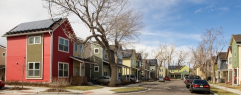 Photo of a street with two-story homes with solar panels on the roof.