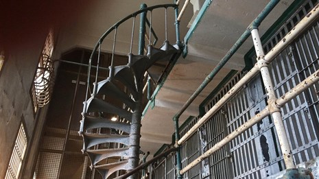 A cell block in Alcatraz with spiral staircase and prison bars