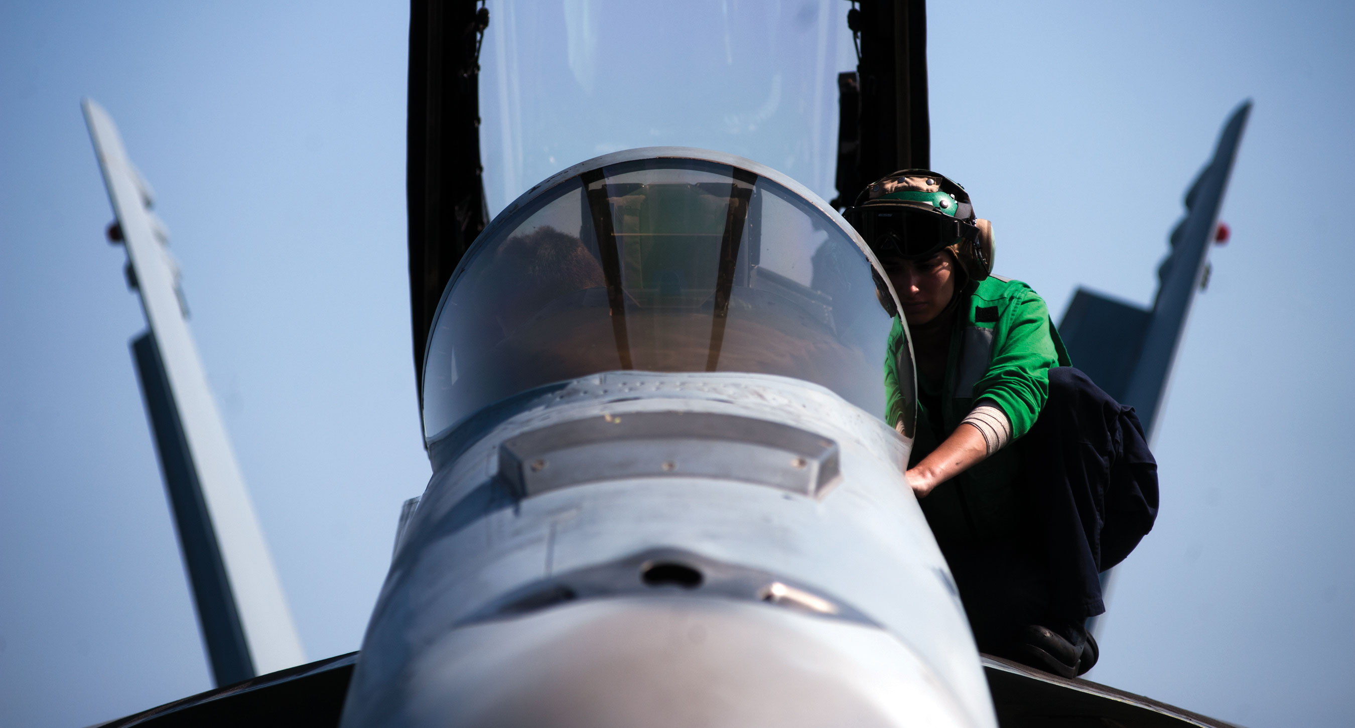 ARABIAN SEA (April 29, 2011) Aviation Electrician s Mate 2nd Class Amanda Mondino, assigned to Strike Fighter Squadron (VFA) 22, reads publications on a laptop as Aviation Electrician Mate Airman Christopher Carter listens in the cockpit of an F/A-18F Super Hornet while performing maintenance on the aircraft's tail-hook assembly aboard the aircraft carrier USS Carl Vinson (CVN 70). U.S. Navy photo by Mass Communication Specialist 3rd Class Travis K. Mendoza.