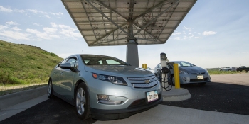 Plug-in hybrid electric vehicles charge at a rapid charging system powered by a solar canopy.