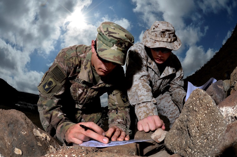 U.S. Army Cpl. Gregory McLellan and U.S. Marine Corps Cpl. Clinton Smith plot grid points during a joint training exercise at Arta, Djibouti. Through informal methods like training exercises, as well as formally established joint forums, the services work together to share new technology and ideas to develop, test and deliver ever-better capabilities for Marines and Soldiers. U.S. Air Force photo by Tech. Sgt. Dan DeCook 