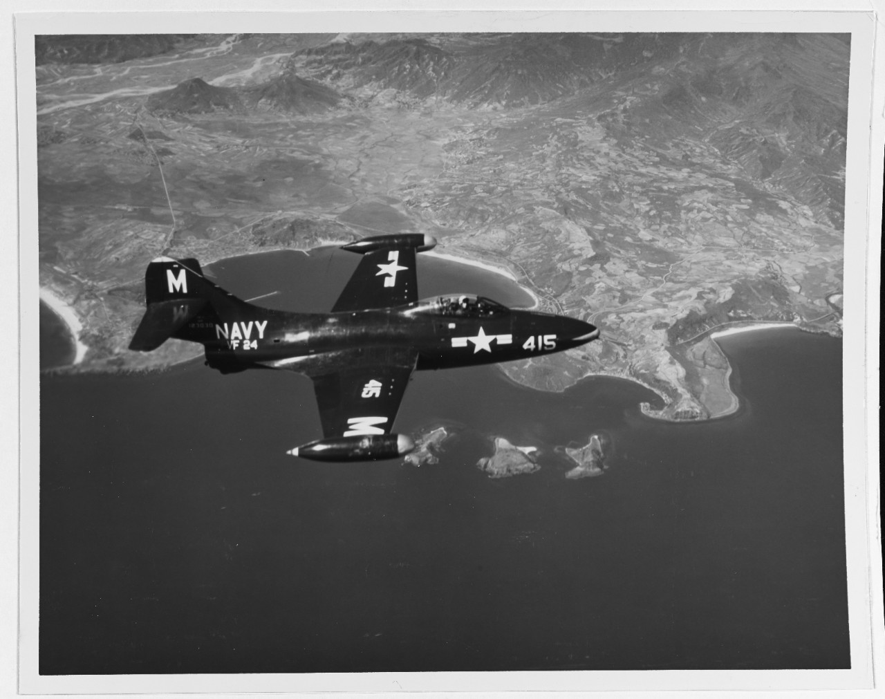 Grumman F9F-2 Panther fighter of Fighter Squadron 24 (VF-24) in flight over Kojo Island, South Korea, June 27, 1952. This plane, based aboard USS Boxer (CV 21), was piloted by Lt. j.g. G.W. Stinnett, Jr. Official U.S. Navy photo courtesy of the National Archives.