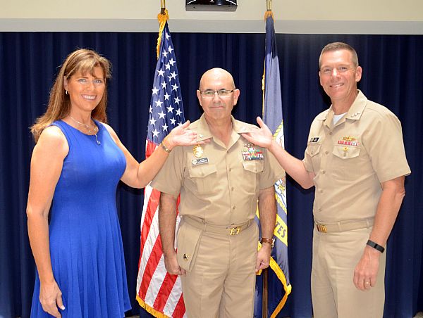 WASHINGTON (Aug. 2, 2016) Capt. David Garlinghouse shows off his new rank insignia with the help of his wife and Commander, Navy Installations Command Vice Adm. Dixon Smith. Garlinghouse became the first ever Navy Reserve security limited-duty officer captain in a promotion ceremony at the Washington Navy Yard. U.S Navy photo by Ed Wright.