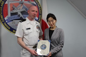 Ms. Shieri Kudo proudly accepting her MLC Incentive Award from CWO2 William Behr