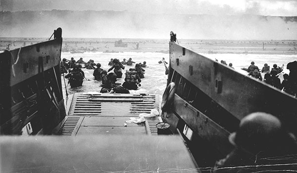 A Coast Guard-manned LCVP from the U.S.S. Samuel Chase disembarks troops on the morning of June 6, 1944, at Omaha Beach. Coast Guard photo by CPHOM Robert F. Sargent  