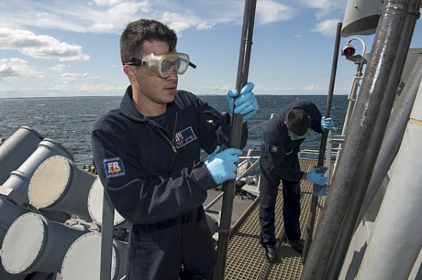 ATLANTIC OCEAN (Sept. 13, 2015) Fire Controlman 3rd Class Jacob Smith, left, from Antioch, Tenn., and Fire Controlman 1st Class David Simangern, from Mesa, Ariz., both assigned to the guided-missile destroyer USS Carney (DDG 64), conduct preventive maintenance on the Phalanx close-in weapons system (CIWS) barrels. Carney is the fourth Arleigh Burke-class destroyer to be forward deployed to Rota, Spain to serve as part of the President's European Phased Adaptive Approach to ballistic missile defense in Europe. Both Sailors are wearing the Navy's new fire retardant coveralls. U.S. Navy photo by Mass Communication Specialist 3rd Class Jonathan B. Trejo.