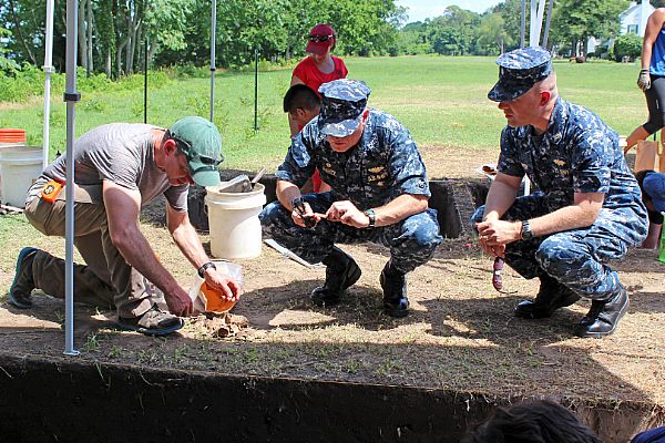 YORKTOWN, Va. (June 15, 2015) Dr. Martin Gallivan, left, an associate professor at the College of William and Mary, shows artifacts found during a field study at Naval Weapons Station Yorktown to Capt. Paul Haebler, commanding officer of Naval Weapons Station Yorktown, and Cmdr. Steven Fichter, Naval Weapons Station Yorktown public works officer. The field study is being conducted through the university as part of an ongoing cooperative agreement with Naval Facilities Engineering Command to survey historical sites aboard the installation. U.S. Navy photo by Mark Piggott.