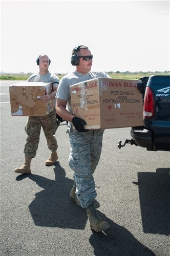 Airmen from the Kentucky Air National Guard’s 123rd Contingency Response Group carry whole blood to a waiting U.S. Air Force C-130 Hercules at Léopold Sédar Senghor International Airport in Dakar, Senegal, Oct. 22, 2014. The blood is being sent to Liberia to support U.S. troops deployed for Operation United Assistance, the U.S. Agency for International Development-led, whole-of-government effort to respond to the Ebola outbreak in West Africa. (U.S. Air National Guard photo by Maj. Dale Greer)