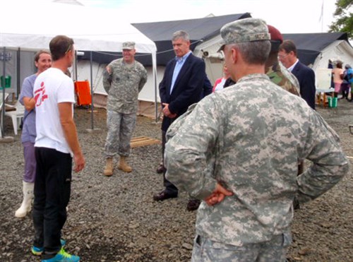 Gen. David M. Rodriguez, commander of U.S. Africa Command (center in civilian attire) speaks with a health worker and doctor who had recently returned from duty in an area known as the hot zone. The hot zone is defined by the double barrier orange fence in the event a sick person falls, they cannot contaminate the clean zone. U.S. Agency for International Development is the lead U.S. Government organization for Operation United Assistance. U.S. Africa Command is supporting the effort by providing command and control, logistics, training and engineering assets to contain the Ebola virus outbreak in West African nations. (U.S. Army Africa photo by Cmdr. Peter Niles/Released)