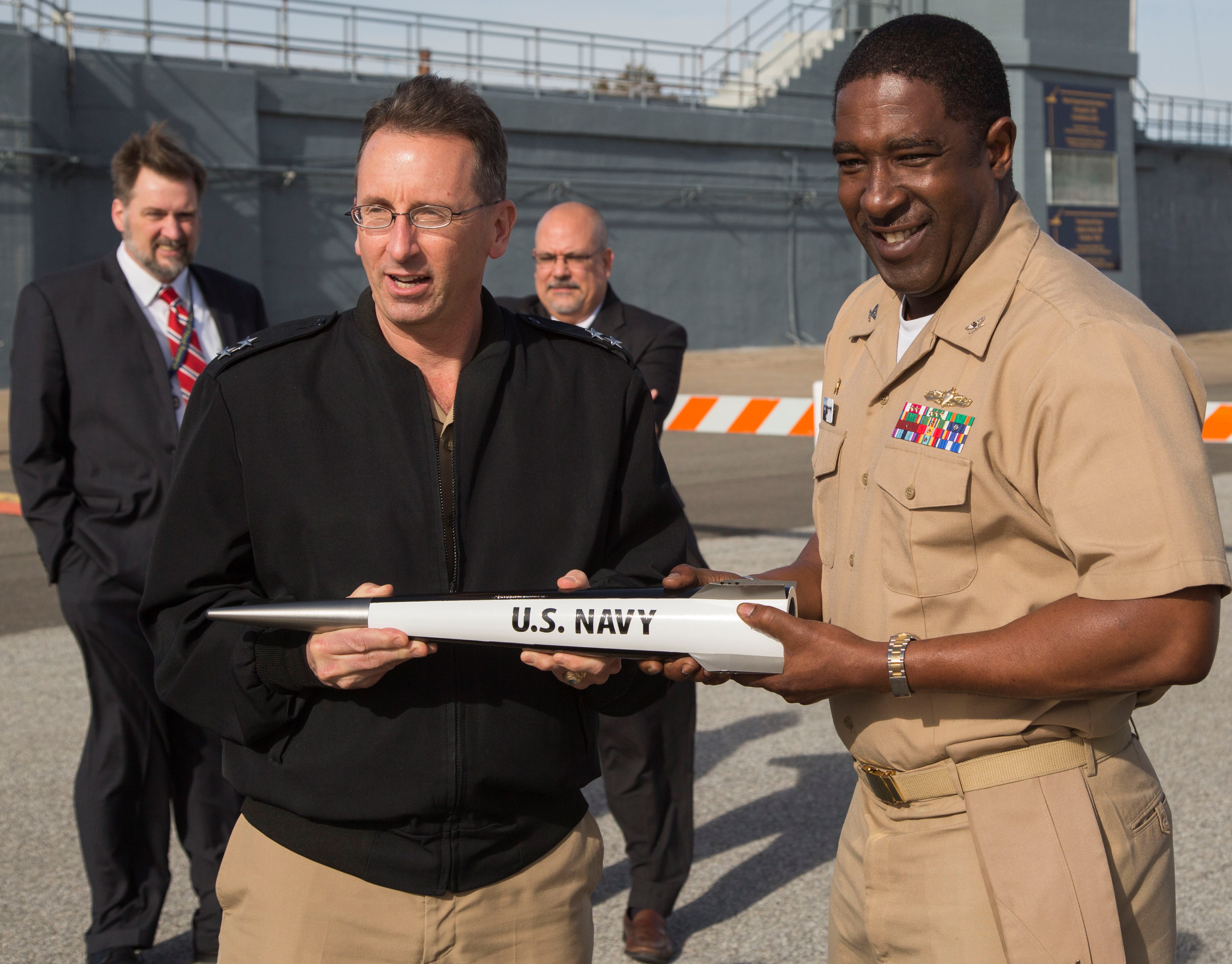 DAHLGREN, Va. - Rear Admiral David Hahn, chief of naval research, and Capt. Godfrey "Gus" Weekes, NSWCDD commanding officer, hold an electromagnetic railgun projectile during Hahn's visit to NSWCDD, Jan. 12. The admiral led his Office of Naval Research (ONR) delegation to see new and emerging ONR sponsored technologies developed at NSWCDD, including directed energy and the electromagnetic railgun. They also watched engineers fire a hypervelocity projectile from a 5-inch, 62-caliber open mount gun at the Potomac River Test Range. U.S. Navy photo by Ryan DeShazo.