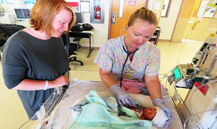 New mom Kimberly Neifert watches NICU Nurse Brandy Lor check the breathing rate of her daughter Ruelyn at Madigan Army Medical Center. Premature babies experience faster heart rates than adults and may also pause longer between breaths due to immature breathing patterns. (U.S. Army photo by Suzanne Ovel)