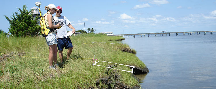 NCCOS researcher and student volunteer map vegetation density on Harkers Island, NC.