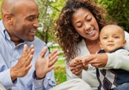 African American Parents Play with Baby in Park