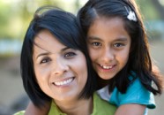 Happy Daughter Hugs Hispanic Single Mother