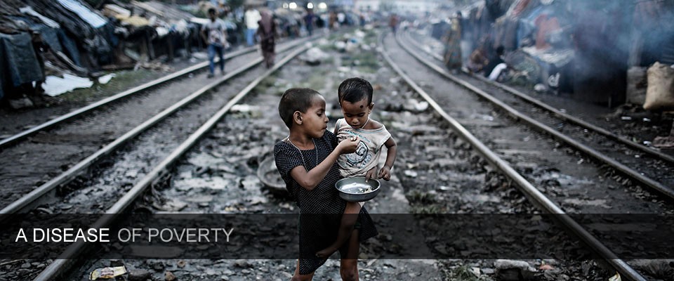 Two young children eating in the middle of train tracks.