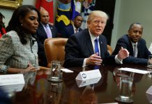 Donald Trump and others seated in a room (© AP Images)