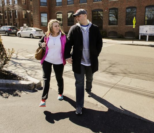 Woman and man walking on sidewalk (© AP Images)