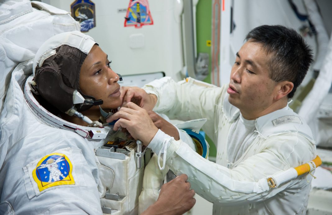 L’astronaute japonais Koichi Wakata en train d'ajuster quelque chose sur la combinaison de Jeanette Epps (NASA)