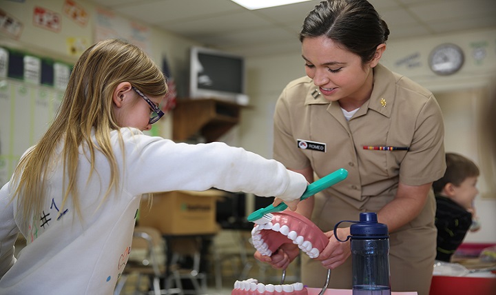 Navy Lt. Michelle Romeo teaches a first-grade student proper brushing techniques during  Dental Health Month at Graham A. Barden Elementary School in Havelock N.C. (U.S. Marine Corps photo by Cpl. Grace L. Waladkewics)
