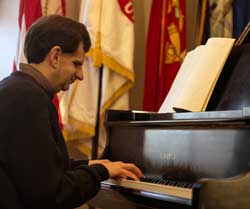 Patron uses braille score and plays piano.