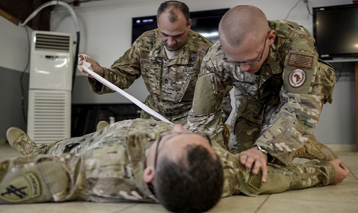 Army Sgt. 1st Class Michael Schiller and Air Force Staff Sgt. Alasdair Stretch participate in the hands on portion of the Combat Lifesavers Course at Camp Lemonnier, Djibouti. The CLC is a 40-hour course centered on the three different phases of tactical combat casualty care: care under fire, tactical field care and casualty evacuation care. (U.S. Air Force photo by Staff Sgt. Christian Jadot)