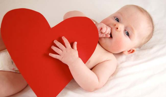 	Baby holding red heart 