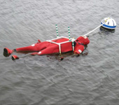 Two moored, life-size, weighted mannequins dressed in Coleman-Stearns Model ISS-590i Adult Universal buoyant immersion suits were observed twice daily from June 8-23, 2016, in tests to determine if extended time in water affected the suits’ flotation capability. U.S. Coast Guard photo.